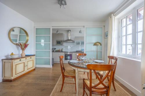 une cuisine et une salle à manger avec une table et des chaises dans l'établissement Appartement Les Goélands - Welkeys, à Trouville-sur-Mer