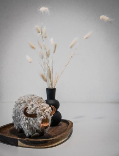 a rock on a wooden plate with two vases at Home Swiss Hotel in Geneva