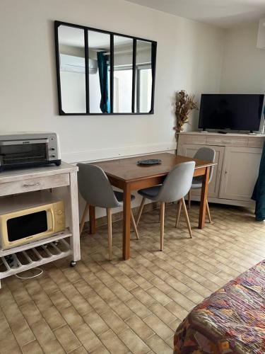 un salon avec une table et des chaises en bois dans l'établissement Studio Mer, au Grau-du-Roi