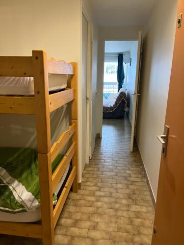 un couloir avec une chambre avec des lits superposés et une porte dans l'établissement Studio Mer, au Grau-du-Roi