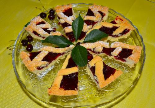 ein Glasteller mit einem Kuchen darauf, bedeckt mit grünen Blättern in der Unterkunft Casale Dionisia, Santa Maria di Castellabate in Castellabate