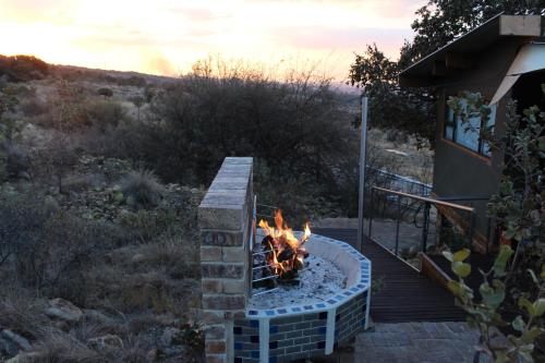 a fire pit in a yard next to a house at Luxury Treehouse on Bronberg Ridge in Tierpoort