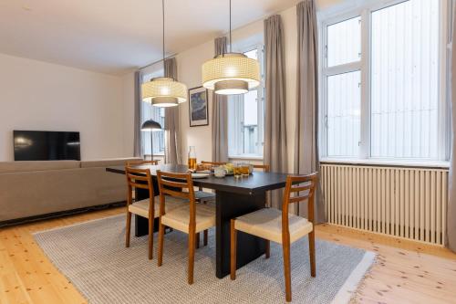 ein Esszimmer mit einem schwarzen Tisch und Stühlen in der Unterkunft Stunning 5 BR Apartment by The Lakes in Kopenhagen