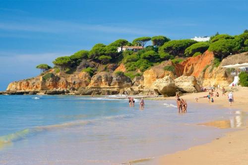 a group of people on a beach in the water at Varanda para o Mar in Albufeira