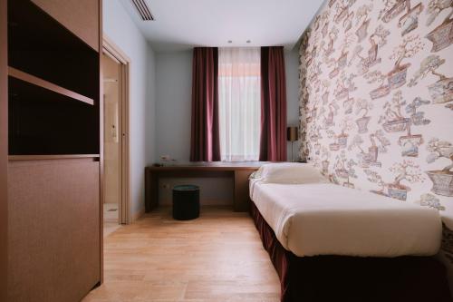 a hotel room with a bed and a wall at Hotel Miramare in Civitanova Marche