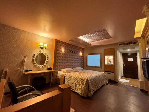 a hotel room with a bed and a mirror at Hua Xiang Motel - Da Chang in Kaohsiung
