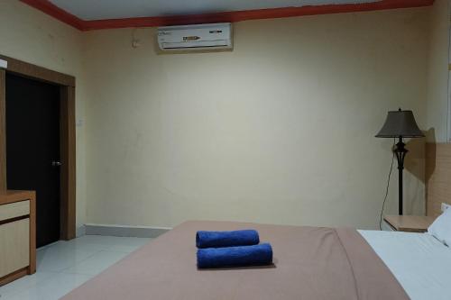 a bedroom with a bed with a blue towel on it at Hotel O Homestay Ananda Luwuk in Bimpang