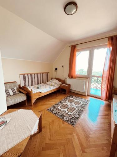 a living room with a bed and a couch at Hubertus Vadászház in Újudvar
