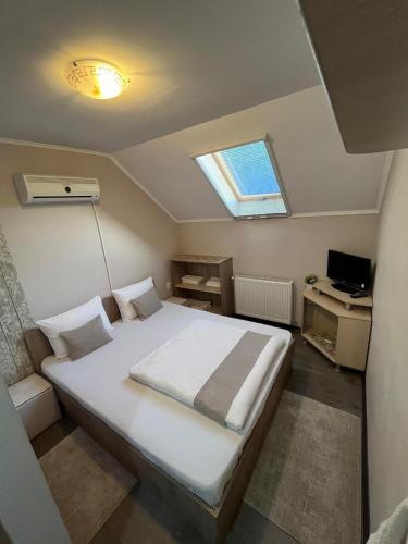 a bedroom with a bed with a window and a desk at Matyas Vendeghaz in Sovata