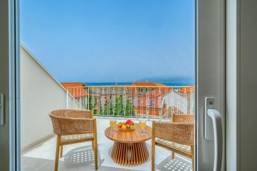 a table with a bowl of fruit on a balcony at Hotel Brattia, Adults Only, Heated Pool, A la Carte Breakfast, Postira, Brač Island in Postira