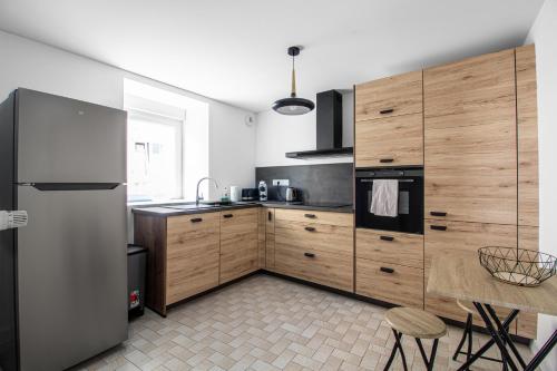 une cuisine avec un réfrigérateur en acier inoxydable et des armoires en bois dans l'établissement Sweet-Bohemian, à Cattenom