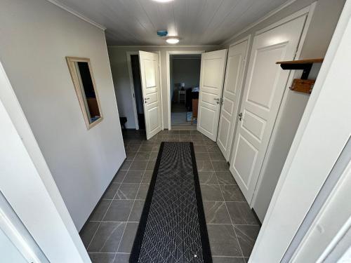a hallway with white doors and a tile floor at Maatilamatkailu Jänisvaara in Kolinkylä