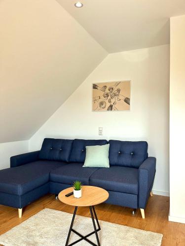 a blue couch in a living room with a table at Ferienwohnung 1595 im Weingut Botzet in Maring-Noviand