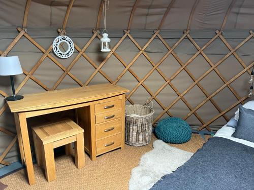 a room with a bed and a desk in a yurt at Nordic Glamping at Botswicky - a nature based retreat in Bishopstone