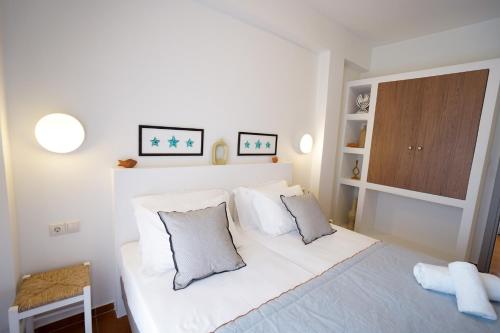 a bedroom with a white bed with two pillows at Agia Marina Apartments 5 Andros in Andros