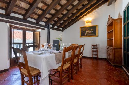 a dining room with a white table and chairs at Casas Rurales Tugasa Castillo de Castellar in Castellar de la Frontera
