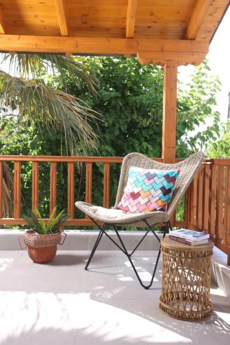 ein Schaukelstuhl auf einer Veranda mit einem Pavillon in der Unterkunft Blue Sand Apartment in Pefkohori