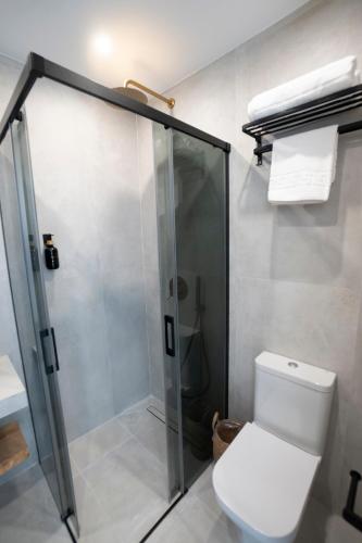 a bathroom with a toilet and a glass shower at La morada de Rosafina in Frigiliana