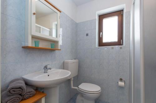 a bathroom with a white toilet and a sink at Camille in Rabac