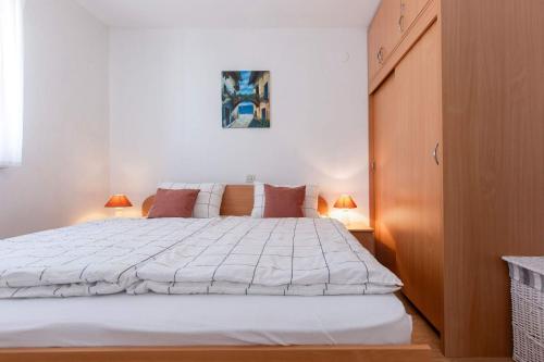 a bedroom with a large white bed with two lamps at Camille in Rabac