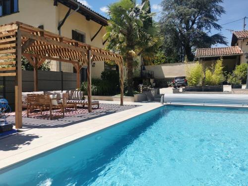 CharnèclesにあるGîte Le Clos d'Olon 4 étoiles avec piscineのパーゴラ付きのスイミングプール、家