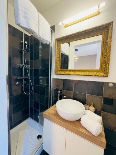 a bathroom with a sink and a tub and a mirror at Arbostora Charme Hotel in Morcote