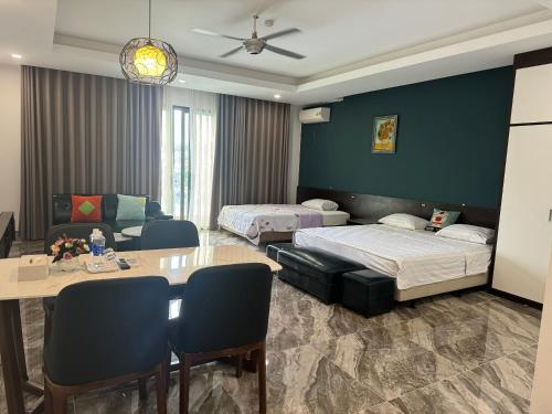 a hotel room with two beds and a table and chairs at Anson Condotel in Ha Long