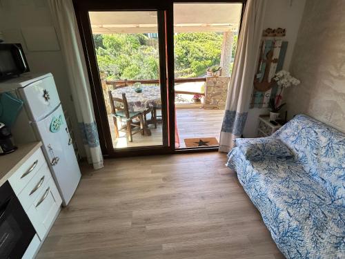 ein Wohnzimmer mit einer Couch und einer Glasschiebetür in der Unterkunft Oasi del Relax - Seaside Peaceful Panoramic Terrace in ITALY - new Sardinia apartment 50 mt beach&sea full comfort air conditioning-WiFi-Parking-Privacy in Torre Dei Corsari