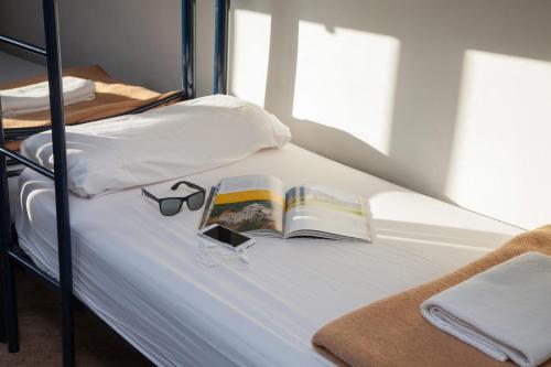 
a bed sitting next to a window with a book at Mellow Barcelona in Barcelona
