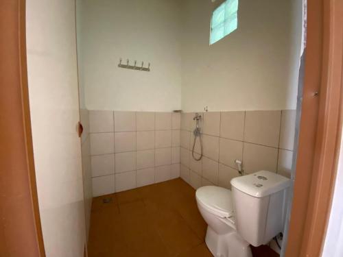 a small bathroom with a toilet and a window at Urbanview Hotel D'Pineapple Villa Ciater by RedDoorz in Subang