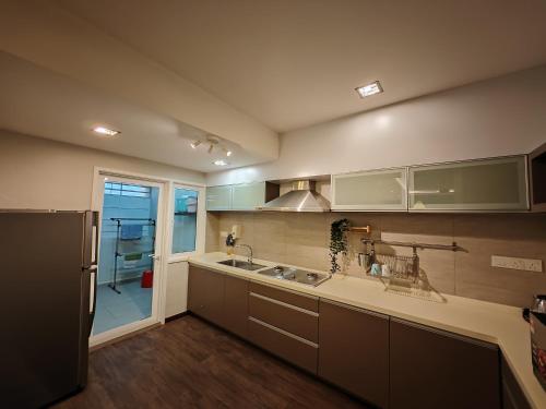 a kitchen with a sink and a refrigerator at Cosy Designer's Home By The Mountain in Lumut