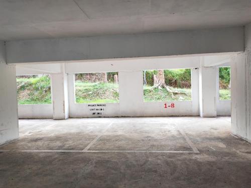 an empty room with four windows in a building at Cosy Designer's Home By The Mountain in Lumut