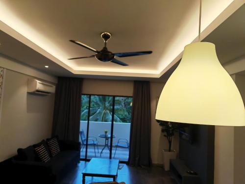 a living room with a ceiling fan and a table at Cosy Designer's Home By The Mountain in Lumut