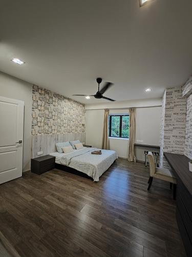a bedroom with a bed and a stone wall at Cosy Designer's Home By The Mountain in Lumut