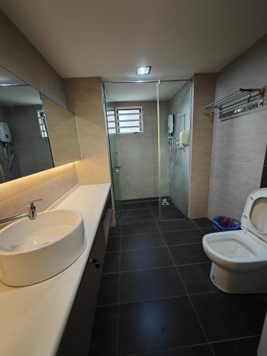 a bathroom with a sink and a toilet and a shower at Cosy Designer's Home By The Mountain in Lumut