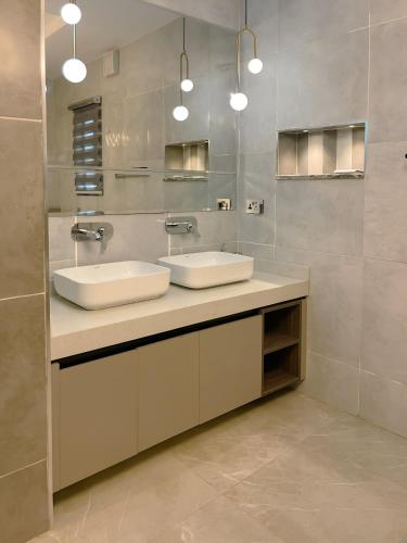 a bathroom with two sinks and a mirror at Apartment in Jahi, Abuja in Jahi