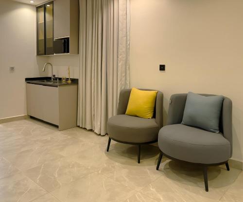 two chairs with a yellow pillow sitting in a room at Apartment in Jahi, Abuja in Jahi