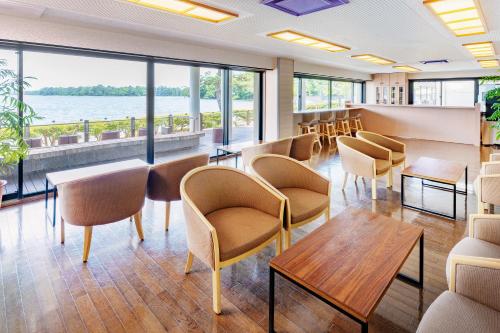 a waiting room with chairs and tables and windows at Amano Hashidate Hotel in Miyazu