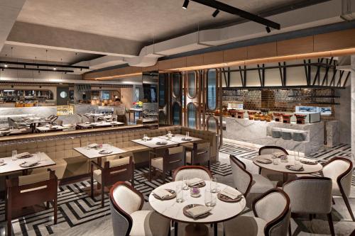 a rendering of a restaurant with tables and chairs at Mövenpick Hotel Jakarta City Centre in Jakarta