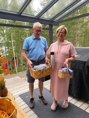 MuurameHideaway cottage的一位年长的男士和一位女士拿着一篮食物