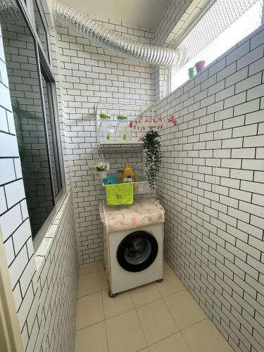 Kampong Alor GajahにあるNaiS Homestayのレンガの壁に洗濯機が付いたバスルーム