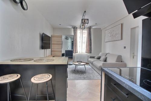 une cuisine et un salon avec un canapé et une table dans l'établissement Le Claire de Lune à Pleyel, à Saint-Denis