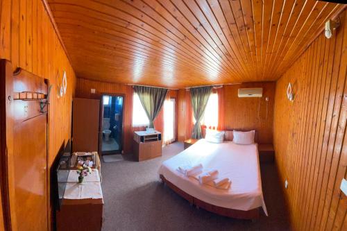 a bedroom with a large bed with a wooden ceiling at Hotel Capu' Turcului in Eforie Sud