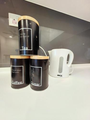 three coffee mugs are sitting on a shelf at Almas Suites スタイリッシュ無印良品スタジオ ステラ国際学校まで徒歩2分 STAY in Nusajaya