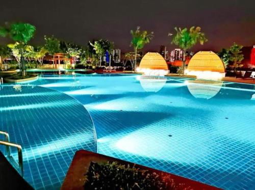 a large swimming pool with blue lights on it at Almas Suites スタイリッシュ無印良品スタジオ ステラ国際学校まで徒歩2分 STAY in Nusajaya