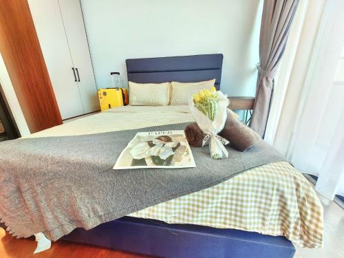 a bed with a tray with a picture and flowers on it at Almas Suites スタイリッシュ無印良品スタジオ ステラ国際学校まで徒歩2分 STAY in Nusajaya
