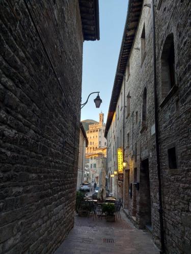 an alley with a table in the middle of a building at BnB Bagno di Bosco in Gubbio