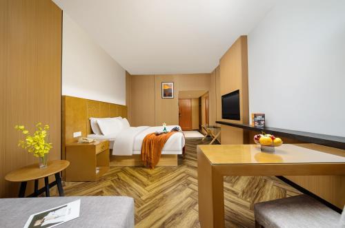 長沙市にあるMellow Orange Hotelのベッドとテレビがあるホテルの部屋