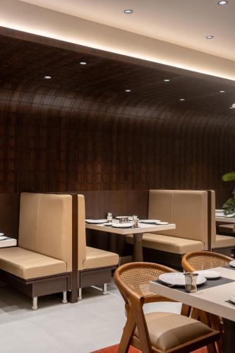 a restaurant with tables and chairs and a wall at Copper Leaf Hotels, Tirunelveli in Tirunelveli