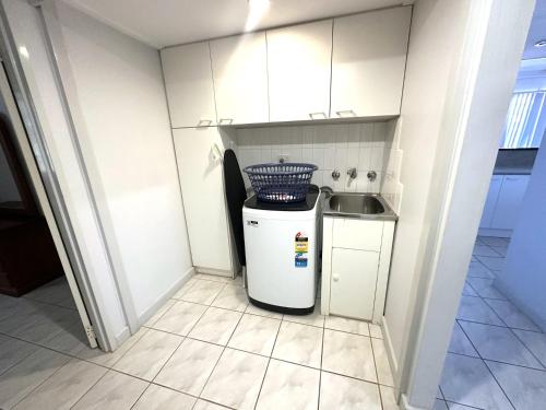 a small white kitchen with a sink and a refrigerator at Osprey Holiday Village Unit 108 in Exmouth